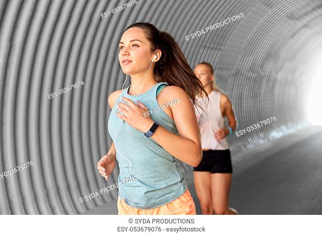 women or female friends with earphones running