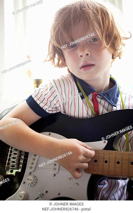 Redheaded boy playing electric guitar, Sweden