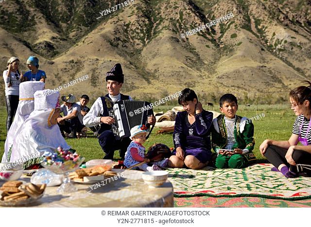 Saty townsfolk some in traditional clothes at a picnic by the Chilik river Kungey Alatau mountains Kazakhstan