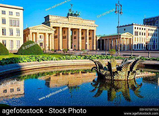 Das berühmte Brandenburger Tor in Berlin mit Spiegelungen in einem Brunnen