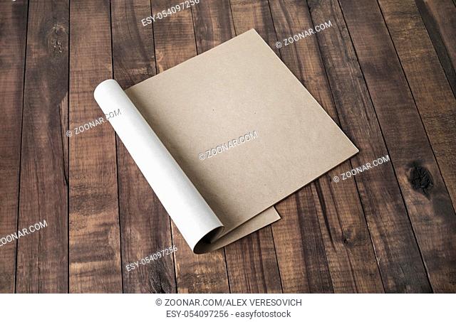 Blank notepad or brochure of kraft paper on vintage wooden background. Mockup for your design