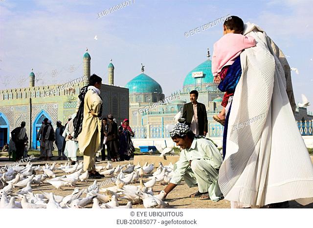 Family feeding famous white pigeons at Shrine of Hazrat Ali (who was assissinated in 661)This shrine was built here in 1136 on the orders of Seljuk Sultan...