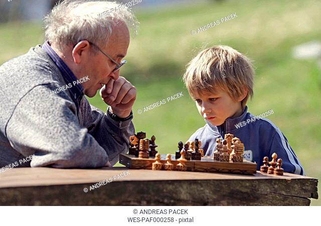 Germany, Rhineland-Palatinate, Leutesdorf, grandfather and grandson playing chess