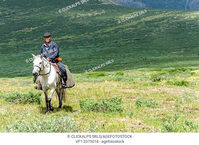 A Tsaatan man rides his horse back to his camp, Tsaatan Camp, Hovsgol Province, Northern Mongolia