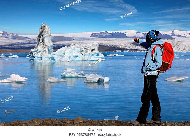 Young woman admires the beauty of the glacial lagoon Jokulsarlon in southeast Iceland