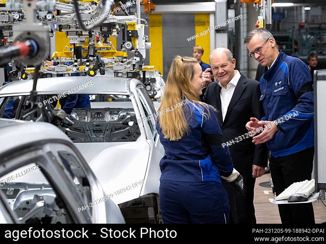 05 December 2023, Bavaria, Munich: Federal Chancellor Olaf Scholz (M, SPD) takes part in a tour of the BMW plant together with Peter Weber