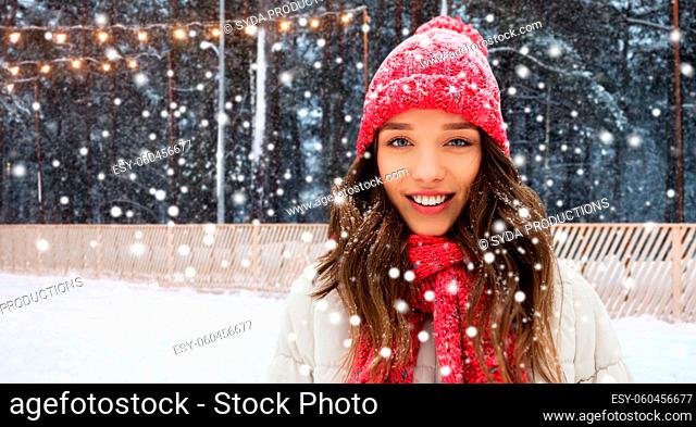 happy teenage girl in winter over skating rink