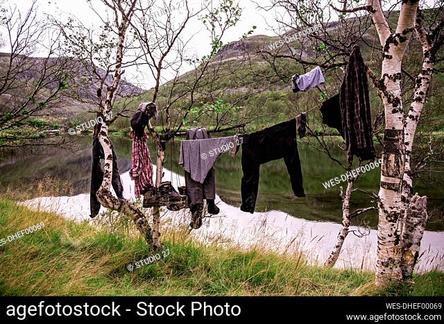 Hiking clothes and boots hanging on clothesline in the countryside, Lakselv, Norway