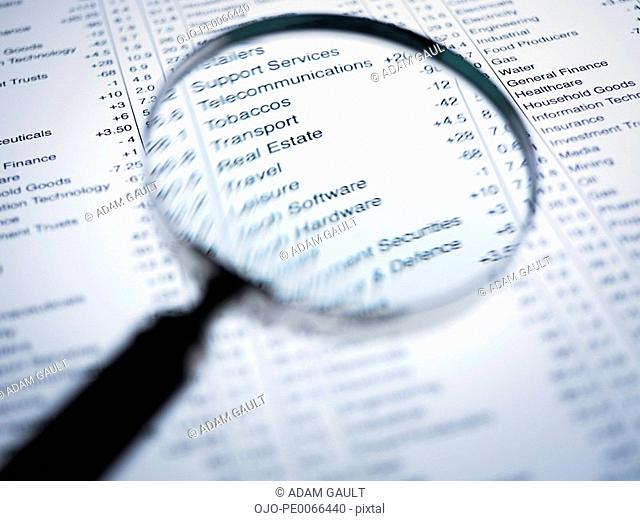 Magnifying glass enlarging list of share prices