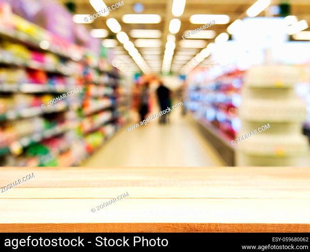 Wooden board empty table in front of blurred background. Perspective light wood over blur in supermarket - can be used for display or montage your products