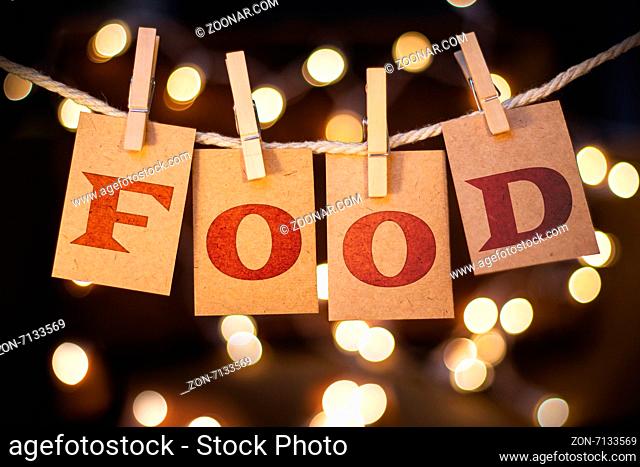 The word FOOD printed on clothespin clipped cards in front of defocused glowing lights