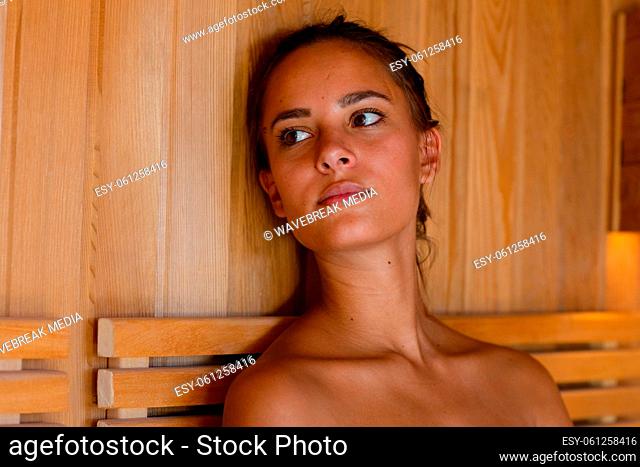 Close up of caucasian young woman in a bathrobe relaxing in the sauna