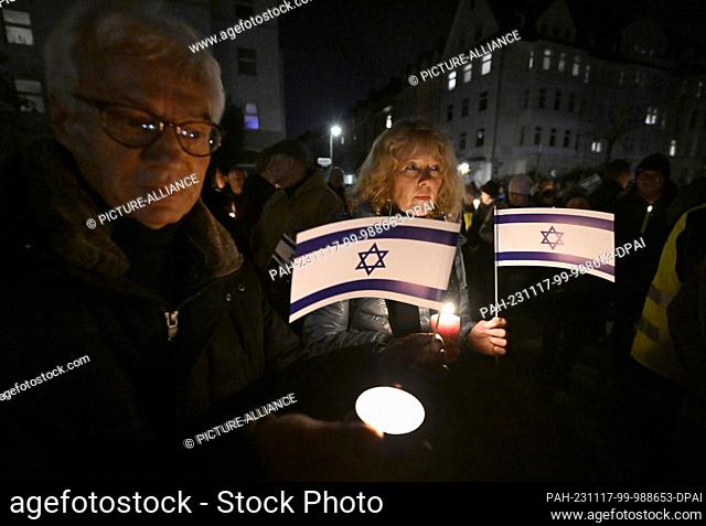 17 November 2023, North Rhine-Westphalia, Duesseldorf: Participants in the chain of lights in solidarity with Israel hold lights and Israel flags in a...