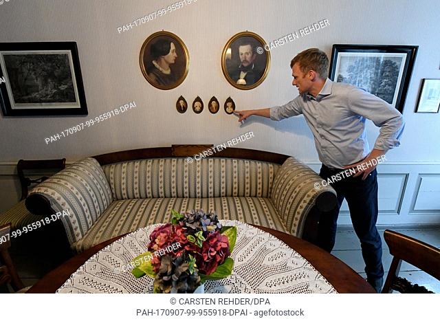 Christian Demandt, director of the Storm Center, points at images of the family in the birth house and residence of Theodor Storm in Husum, Germany