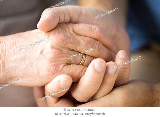 close up of senior couple holding hands