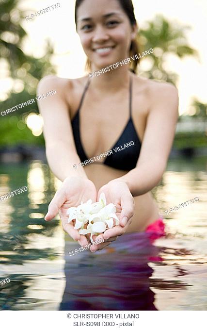 Woman in water holding flowers
