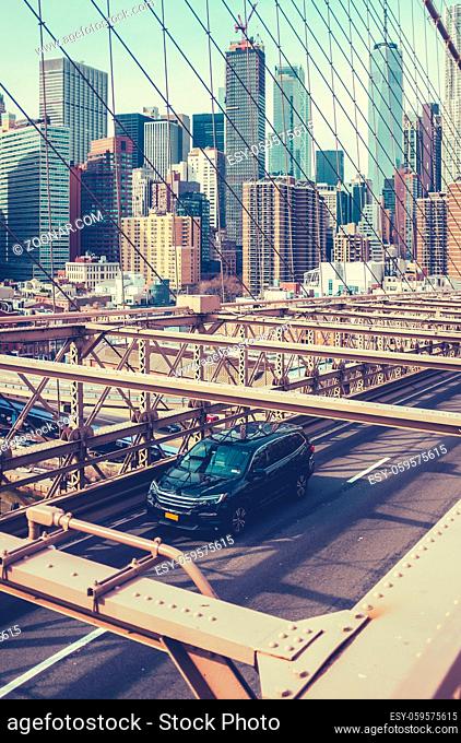 A Car Speeding Across Brooklyn Bridge With The Manhattan Skyline In The Background