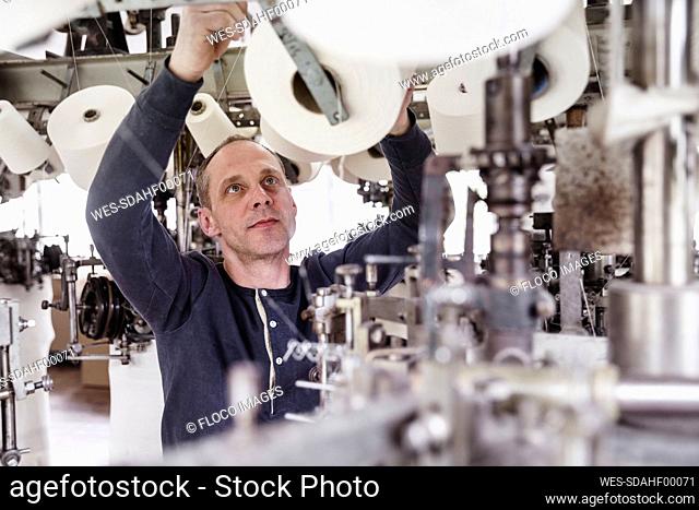 Man working at a machine in a textile factory