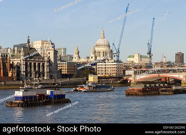 London, England - Aril 1, 2012: The River Thames with ships and boats and the city of london with St. Paul's Cathedral and buildings