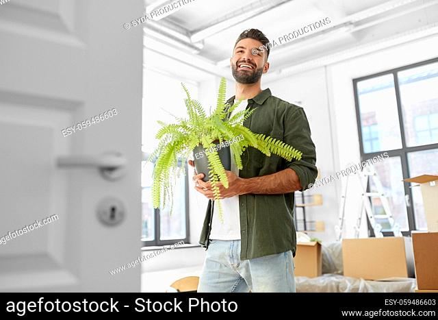 happy man with fern flower and moving to new home