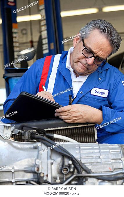 Mechanic writing down something on clipboard