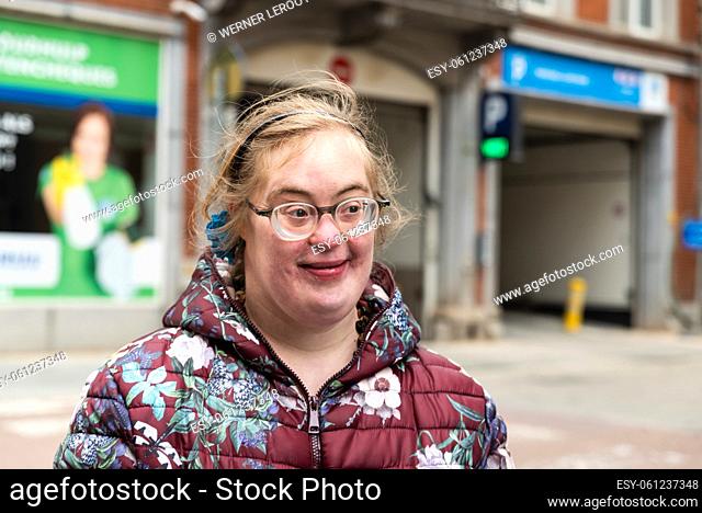 Close up outdoor portrait of a smiling 39 year old white woman with Down Syndrome, Tienen, Belgium