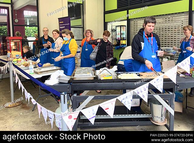 21 May 2022, Australia, Sydney: Election workers fry sausages outside a polling station at the International Grammar School on Kelly Street in Sydney, Australia