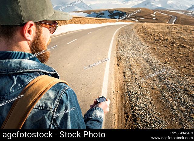 Close-up Hipster man using a compass on a snowy mountain