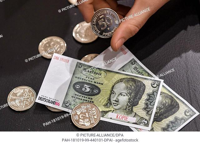 17 October 2018, Berlin: Counterfeit D-Mark coins and bills to pay for in the 80s pop-up store at Hackescher Markt, which was opened with a party at the start...