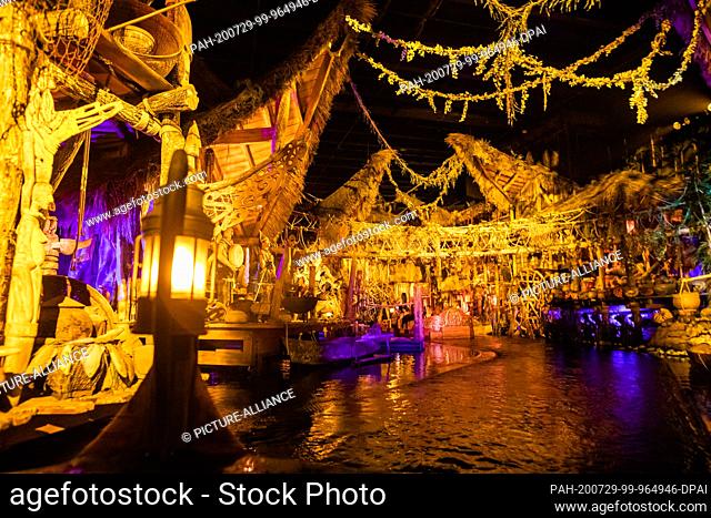 28 July 2020, Baden-Wuerttemberg, Rust: Elaborately decorated huts are set against the backdrop of the attraction ""Pirates in Batavia"" on the Europa-Park...