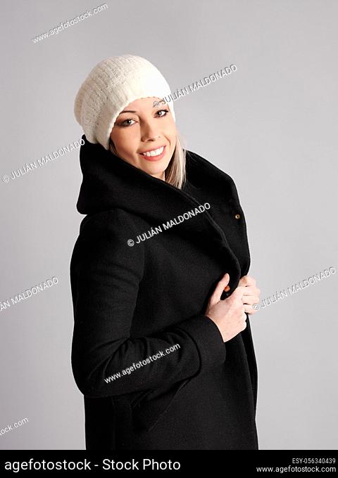 Pretty young woman poses with cheerful and friendly winter and fitness clothes