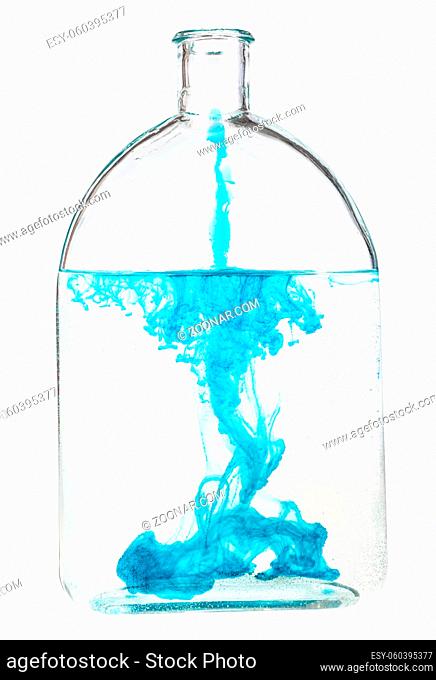 blue ink dissolves in water in bottle isolated on white background