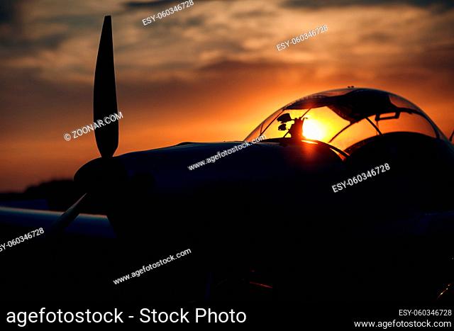 Small private single engine propeller airplane at sunset regional airport