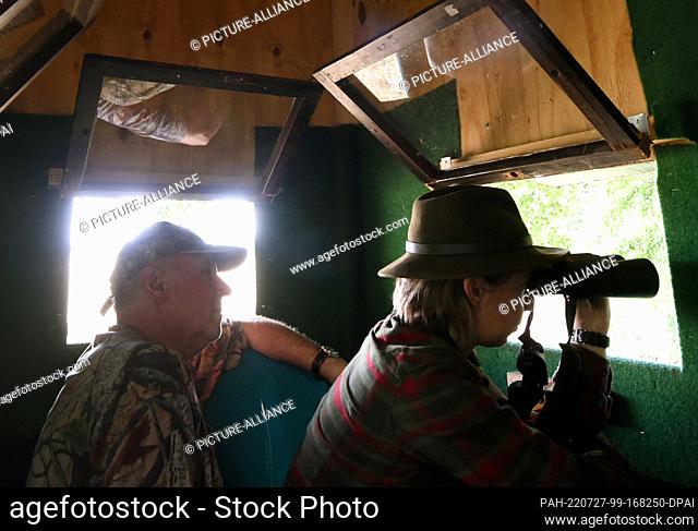 24 July 2022, Saxony, Mörtitz/Laußig: The 32-year-old hunter Cynthia Hillscher sits with her husband Hartmut, who is also a hunter