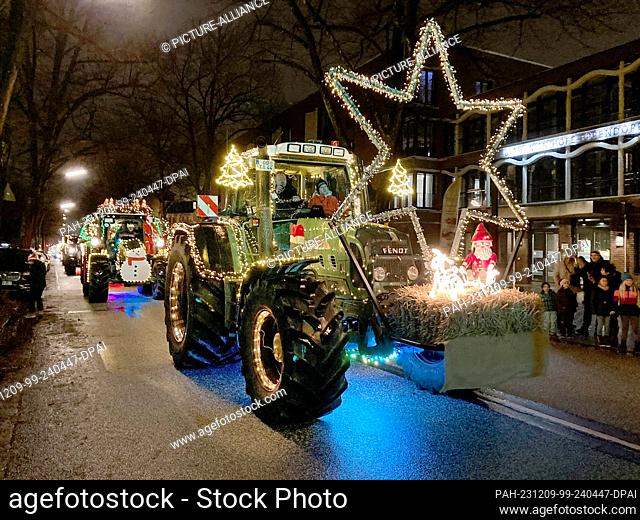 09 December 2023, Storman, Hamburg: Tractors decorated for Christmas driving along a road. Farmers from Eichede (Stormarn district) brought donations to the...
