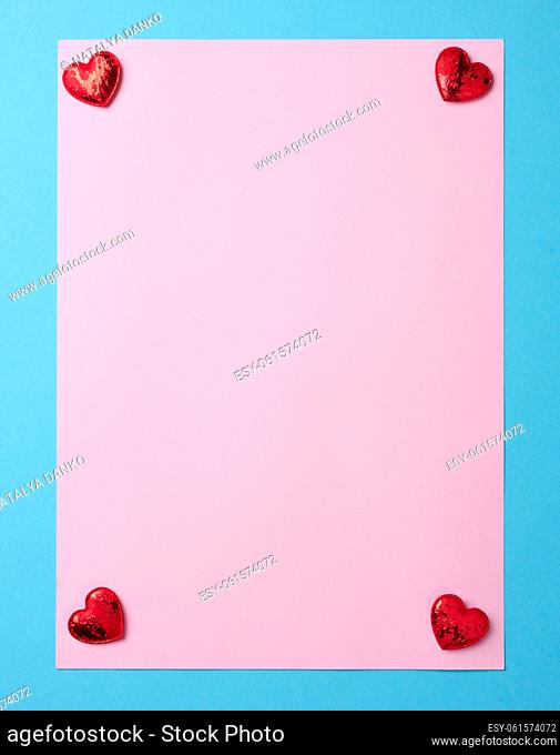 Empty pink paper sheet on blue background, copy space