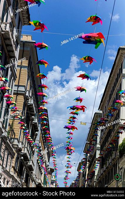 via roma street in genoa, italy, decorated with colorful umbrellas on top