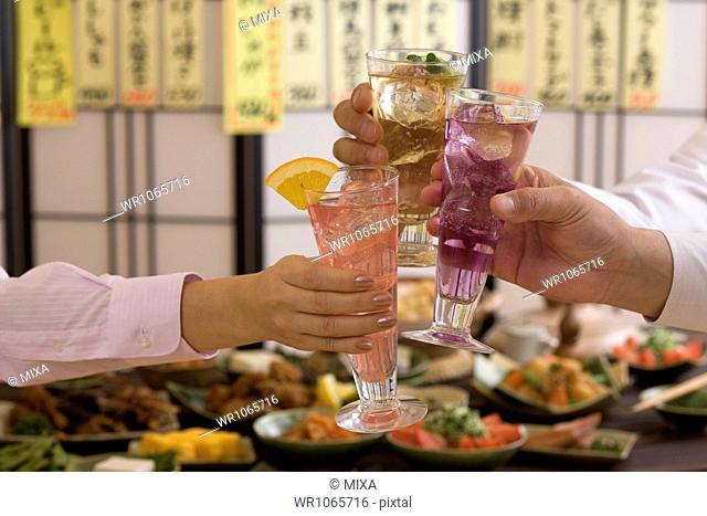Three People Toasting with Various Cocktails at Izakaya