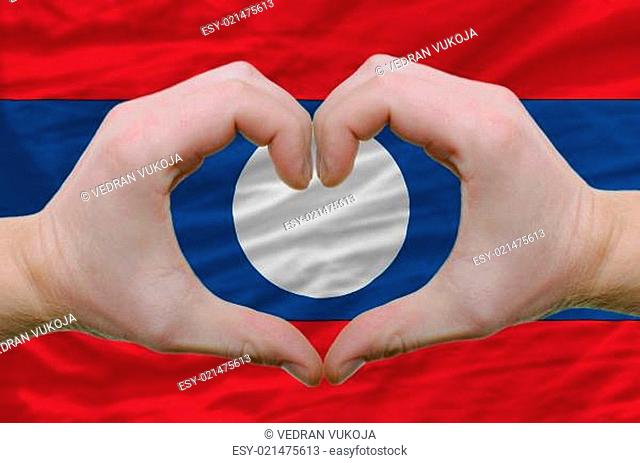 Heart and love gesture showed by hands over flag of laos backgro
