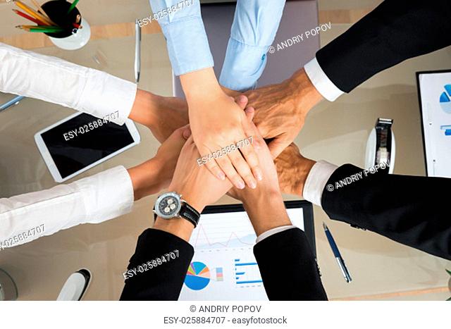 High Angle View Of Businesspeople Stacking Hands In Office