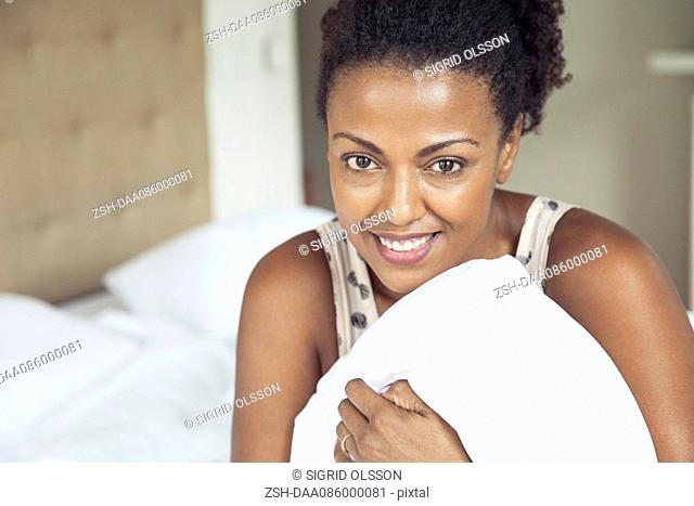 Woman holding pillow, portrait