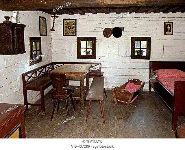 interior view from an old cottage farmhouse room with table bench bed and cradle in the flower park Mozirski Gaj in the town Mozirje in the in the valley of the...