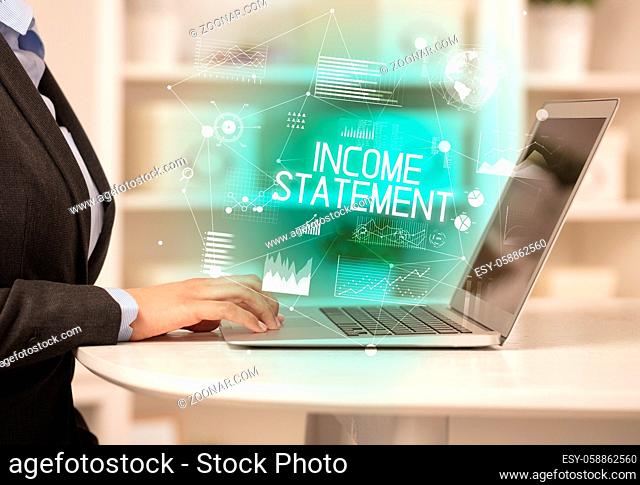Side view of a business person working on laptop with INCOME STATEMENT inscription, modern business concept