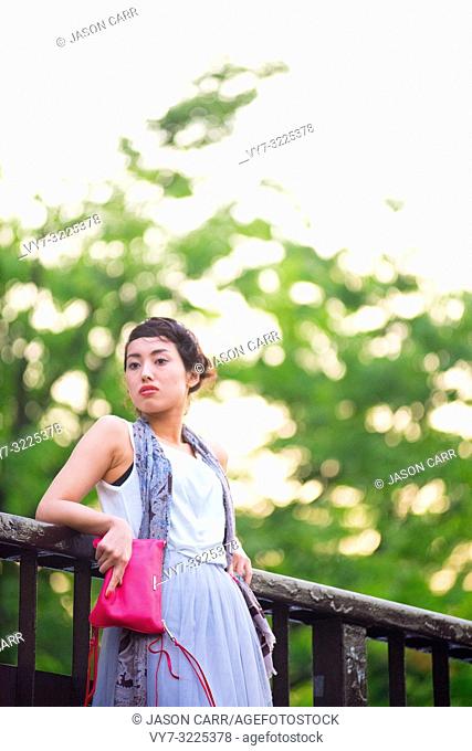 Asian female model poses for pictures in the cityscape