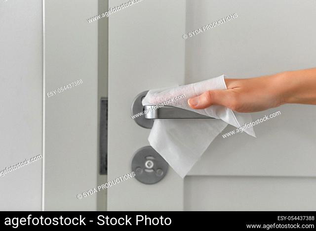 hand cleaning door handle with antiseptic wet wipe