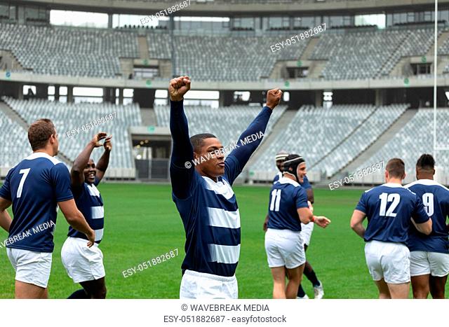 Diverse male rugby players celebrating goal in stadium