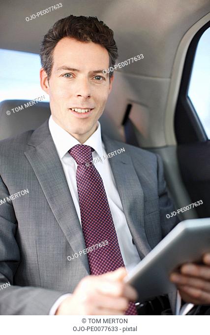 Politician sitting in backseat of car