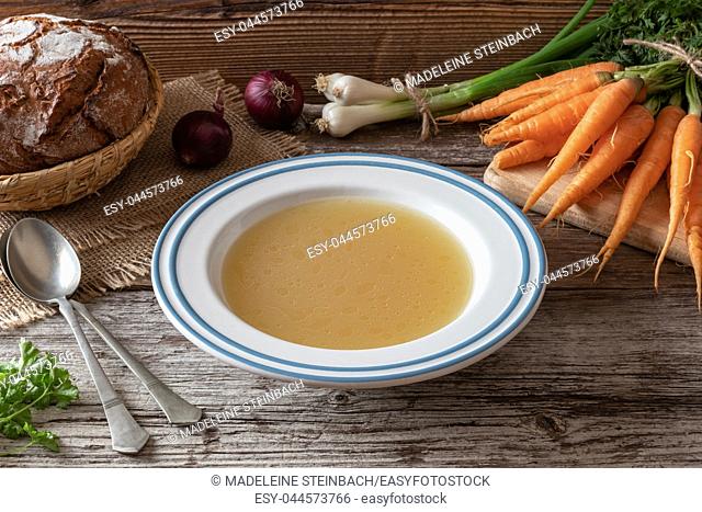 Chicken bone broth with fresh vegetables and sourdough bread