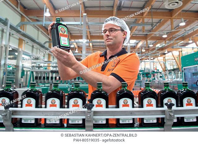 Production employee Thomas Berger holds up a bottle of Jaegermeister in the Mast-Jaegermeister SE filling station in Kamenz, Germany, 19 May 2016