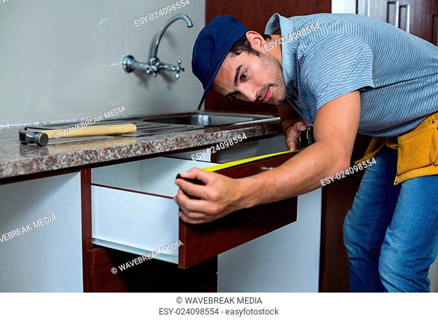Man measuring drawer size